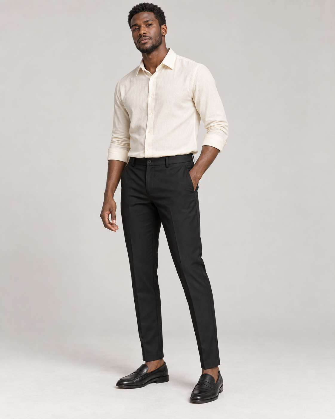 Studio model wearing refined black Vedko ankle-fit trousers